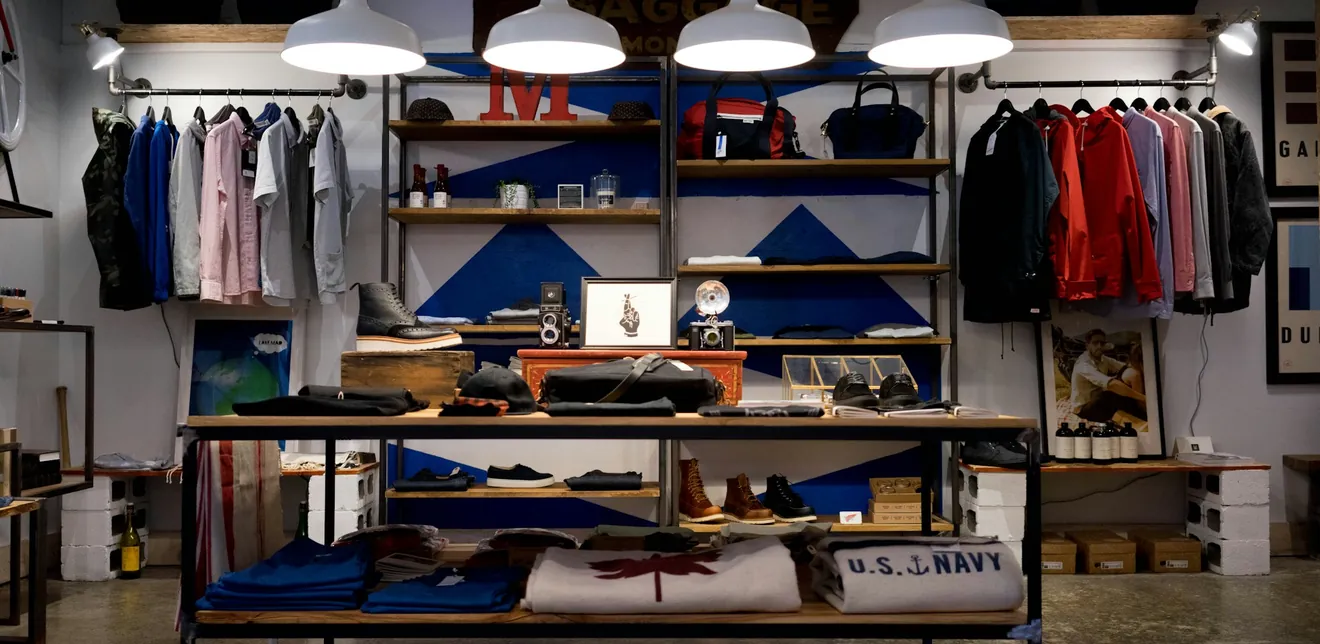 Store interior with clothing rails, shelves and shoes